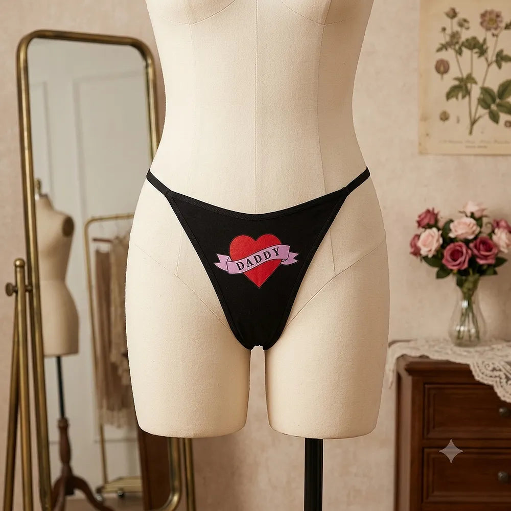 Women's black DADDY thong with red heart graphic from side angle