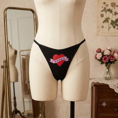 Women's black DADDY thong with red heart graphic from side angle