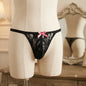 Women's black floral lace thong front view with pink bow
