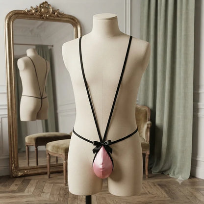 Front display of pink men's thong with long black straps running over the shoulders