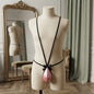 Front display of pink men's thong with long black straps running over the shoulders